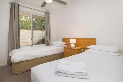 two beds in a room with a window at 20CapeView Geographe bay in Busselton