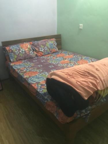 a bed in a room with a flowery comforter at Little Heaven restaurant &guest house in Deorāli