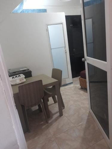 a dining room with a table and chairs and a door at La fantástica Mi Hostal in Cartagena de Indias