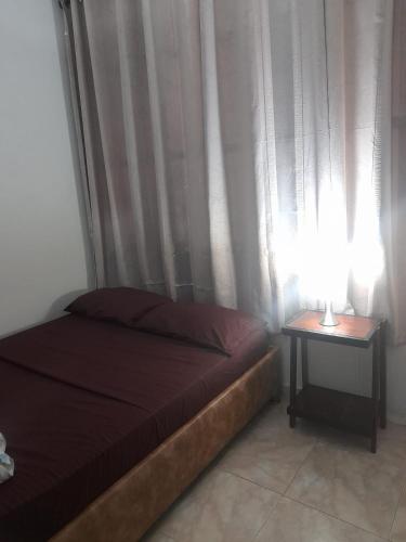 a bedroom with a bed and a table with a lamp at La fantástica Mi Hostal in Cartagena de Indias
