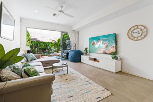 a living room with a couch and a clock on the wall at Abby's Burleigh Haven Unit 2 in Gold Coast