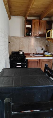 Una cocina con una mesa y una estufa dentro. en Morita, en Comandante Luis Piedrabuena