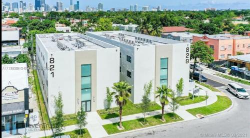 an aerial view of a white building with palm trees at Modern Bedroom In Central Miami in Miami