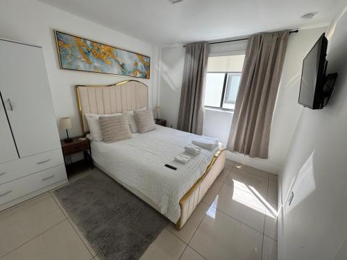 a bedroom with a bed with a television and a window at Modern Bedroom In Central Miami Shared with host in Miami