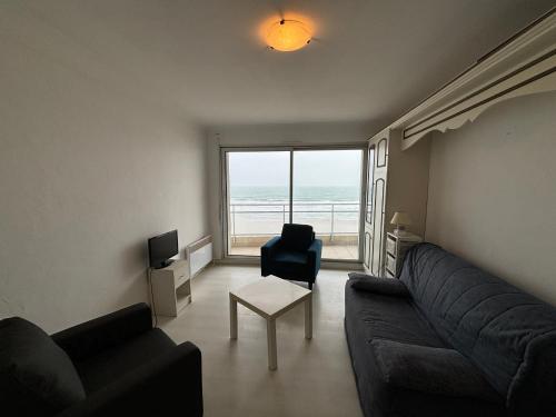 - un salon avec un canapé, une chaise et une fenêtre dans l'établissement Studio spacieux avec balcon, vue mer, Les Sables d'Olonne - FR-1-197-618, à Les Sables-dʼOlonne