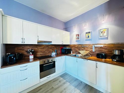 une cuisine avec des armoires blanches et un comptoir dans l'établissement Charmante maison à 200m de la plage pour 5 personnes - FR-1-709-94, à Fouras