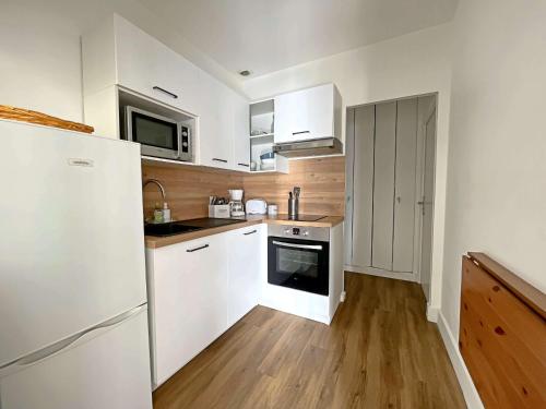 une cuisine avec des armoires blanches et un réfrigérateur blanc dans l'établissement Charmant T3 entre Plage et Village à Berck-Plage - FR-1-646-85, à Berck-sur-Mer