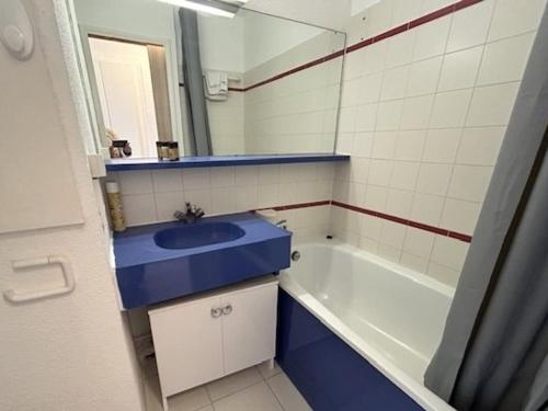 La salle de bains est pourvue d'un lavabo bleu et d'une baignoire. dans l'établissement Cannes la Bocca: Appartement 2 Pièces avec Terrasse et Piscines - FR-1-609-110, à Cannes