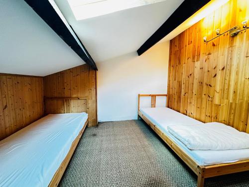 deux lits dans une chambre aux murs en bois dans l'établissement Charmante maison à 200m de la plage pour 5 personnes - FR-1-709-94, à Fouras