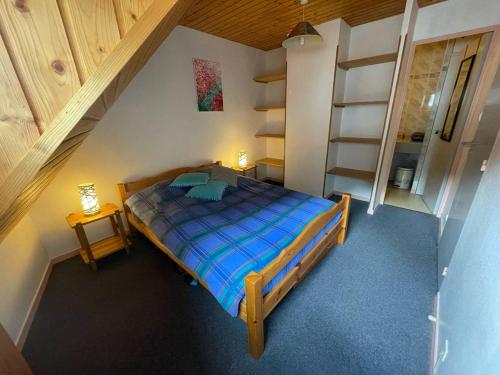 une petite chambre avec un lit et un escalier dans l'établissement Duplex 39m², central à Cauterets, proche toutes commodités - FR-1-812-132, à Cauterets