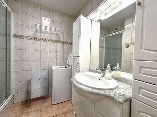 une salle de bain blanche avec un lavabo et un miroir dans l'établissement Appartement T3 avec Terrasse et Clim à 300m de la Plage - FR-1-226B-234, à Cavalaire-sur-Mer