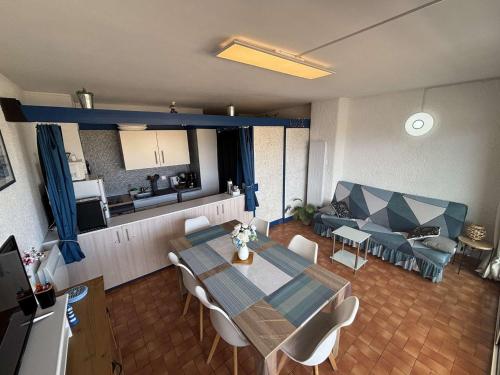 un salon avec une table et un canapé dans l'établissement Appartement 2 pièces cabine, proche plage, balcon - FR-1-229C-104, à Port-la-Nouvelle