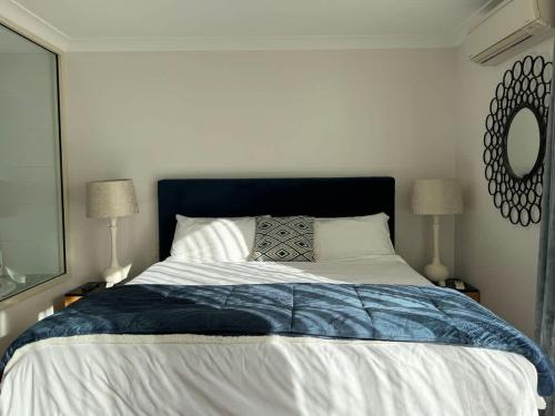 a bedroom with a blue and white bed with two lamps at 5@CapeView, beachfront Geographe Bay in Busselton