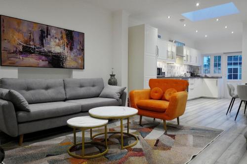 a living room with a couch and a chair and a table at Luxury home in prime location Steps from WoodGreen in London
