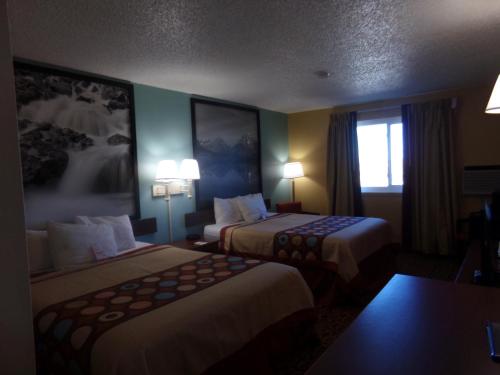 a hotel room with two beds and a window at Super 8 by Wyndham Gillette in Gillette