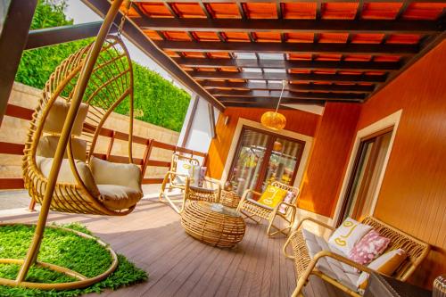 a porch with wicker chairs and a porch swing at Casas das Pedrinhas by Paisagens Inéditas in Travanca