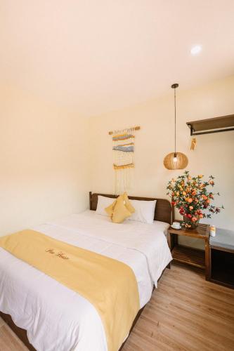 a bedroom with a bed and a vase of flowers at Pan House Bắc Hà in Bắc Hà