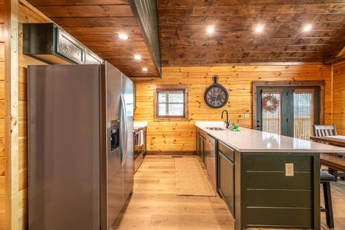 a kitchen with a stainless steel refrigerator and wooden walls at Cozy Mountaintop Cabin with Firepit, HotTub & Views! in Sevierville