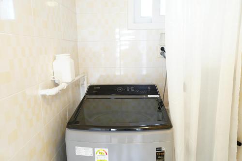 a washing machine in a corner of a bathroom at Residence Unicorn in Seoul