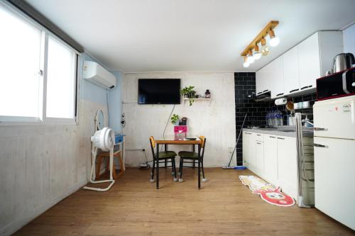 a kitchen with a table and a tv on the wall at Residence Unicorn in Seoul