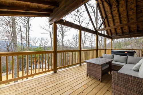 a screened in porch with a couch and a table at Cozy Mountaintop Cabin with Firepit, HotTub & Views! in Sevierville