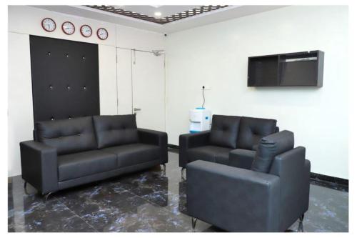 two black leather couches and a tv in a room at Hotel opal plaza executive in Waluj Buzurg