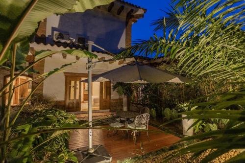a patio with an umbrella in front of a house at Visus Hotel Boutique & Spa in Pereira