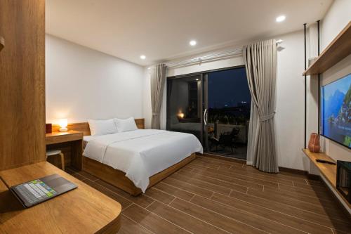a hotel room with a bed and a television at The Literature'N Central Hotel and Travel Ha Noi 177 in Hanoi