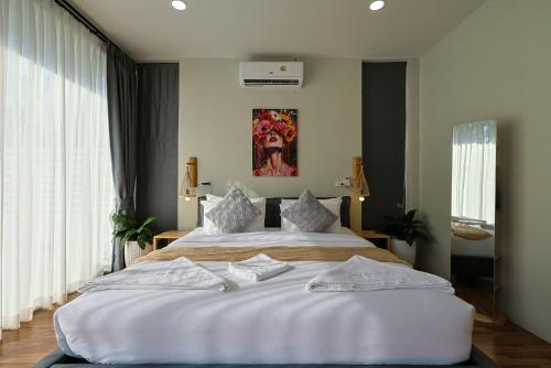 a bedroom with two beds with white sheets at Villa Luna Mara in Koh Phangan