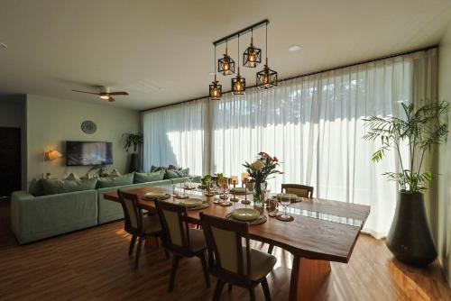 a dining room with a table and a couch at Villa Luna Mara in Koh Phangan
