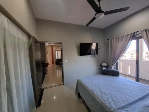 ein Schlafzimmer mit einem Bett und einem Deckenventilator in der Unterkunft Departamentos La Roca D7 in La Peñita de Jaltemba