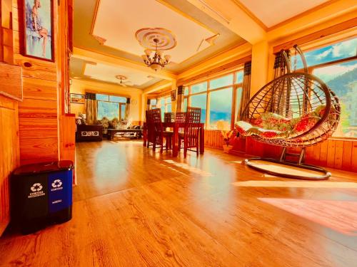 a living room with a table and chairs and a swing at Woods Villa Cottages Manali - 1,2,3,4 Cottages & Villas Available in manali with scenic mountain view in Manāli