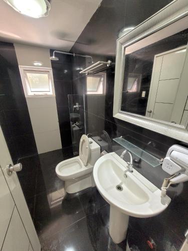 a bathroom with a sink and a toilet and a mirror at Lucky Suite Kandi 2 bedrooms in Angeles