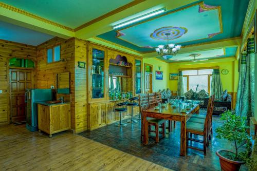 a kitchen and dining room with a table and chairs at Woods Villa Cottages Manali - 1,2,3,4 Cottages & Villas Available in manali with scenic mountain view in Manāli
