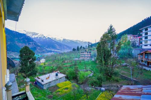 a view of a valley with houses on a hill at Woods Villa Cottages Manali - 1,2,3,4 Cottages & Villas Available in manali with scenic mountain view in Manāli