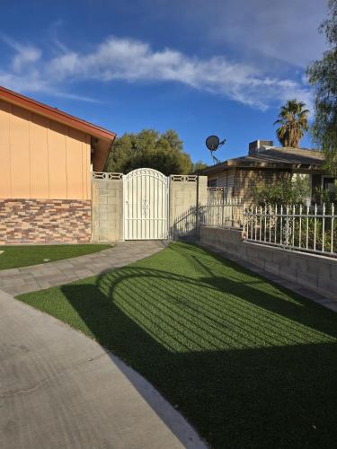 a fence in a yard next to a house at Apartment in Las Vegas