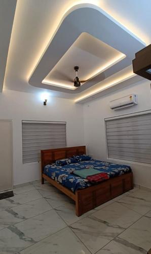 a bedroom with a bed and a ceiling at Premium 4 Bedroom Villa in Kannur in Edakkād