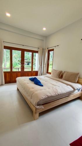 a large bed in a room with windows at 2-Bedroom Maduea Wan House in Ko Phangan