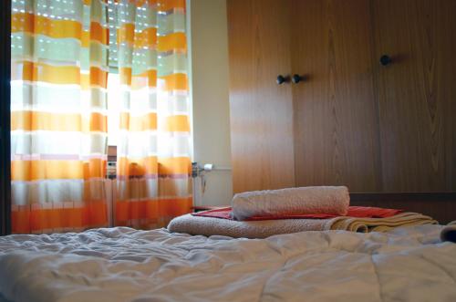 a bedroom with a bed and a curtain and a window at Apartment Relax in Zrenjanin