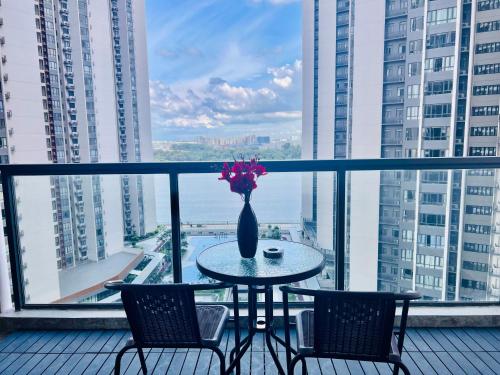 a table with chairs and a vase with flowers on a balcony at R&F Seine Region in Johor Bahru
