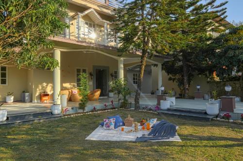 a house with a picnic table in the yard at SaffronStays Mont Tierra - 4BR modern villa with lawn, bonfire, indoor games & themed rooms, Dehradun in Dehradun