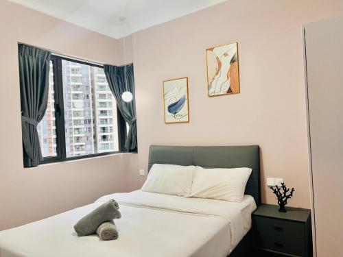 a bedroom with a bed with a stuffed animal on it at R&F Seine Region in Johor Bahru