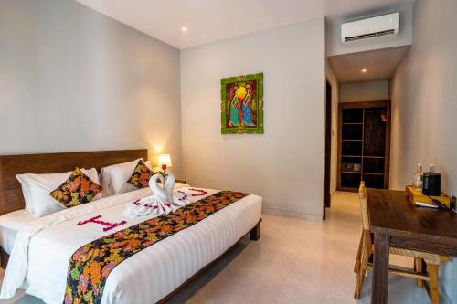 a bedroom with a bed and a table and a desk at Samadiya Canggu in Canggu