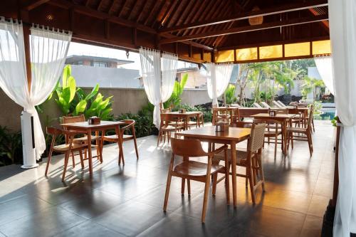 a restaurant with wooden tables and chairs on a patio at Samadiya Canggu in Canggu