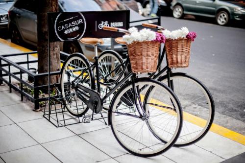 a bike parked on a sidewalk with two baskets at CasaSur Bellini in Buenos Aires