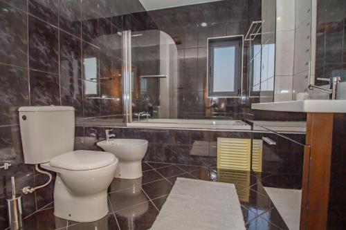 a bathroom with a toilet and a sink and a tub at Casa do Douro& Porto in Lousada