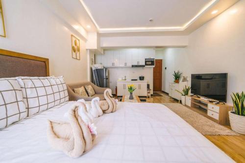 a living room with a white bed with towels on it at JYL Royal Oceancrest Mactan Condo Staycation in Mactan Island