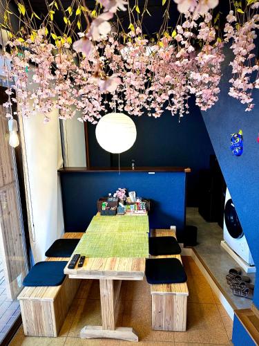 a table and benches in a room with flowers on the ceiling at AYA-KAMOJIMA in Yoshinogawa