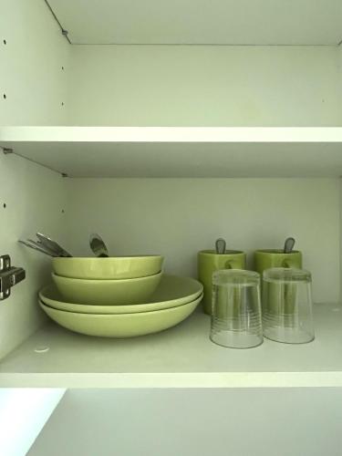 a shelf with two bowls and two cups on it at Des Res Hotel and Residence in Bangna