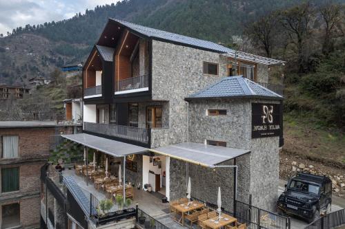 a building with a restaurant on the side of it at Echor Noah Villa Tirthan Valley in Gushaini